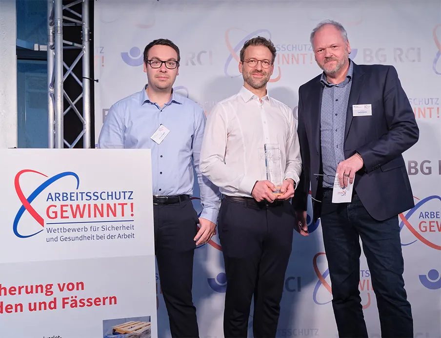 Gewinner des Arbeitsschutz-Wettbewerbs: Jonas Binninger und Andreas Unterhuber von Wacker Chemie mit Thomas Leitmann, Vorsitzender des Präventionsausschusses der Vertreterversammlung der BG RCI